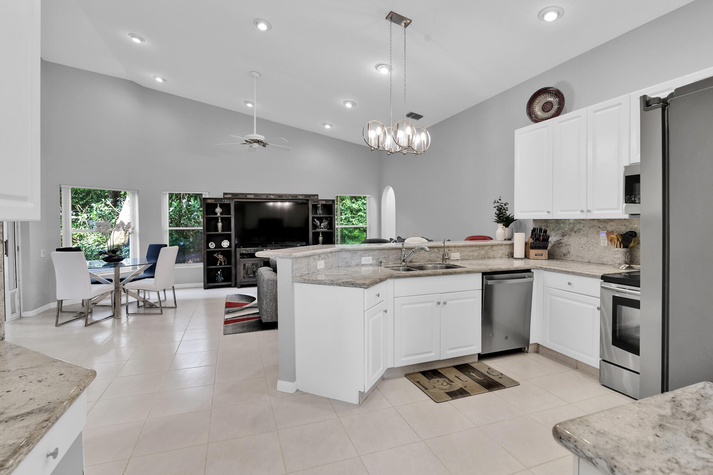 7458 Falls Road West Boynton Beach, FL 33437 - Photo 10 of 45 a kitchen with a sink stainless steel appliances and living room view