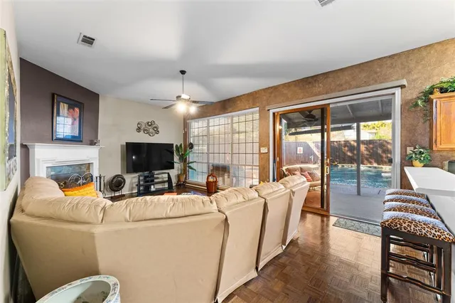 a living room with furniture a flat screen tv and a floor to ceiling window