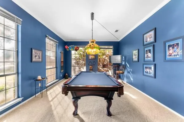 a room with pool table and windows