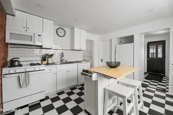a kitchen with stainless steel appliances a sink a stove a refrigerator and cabinets