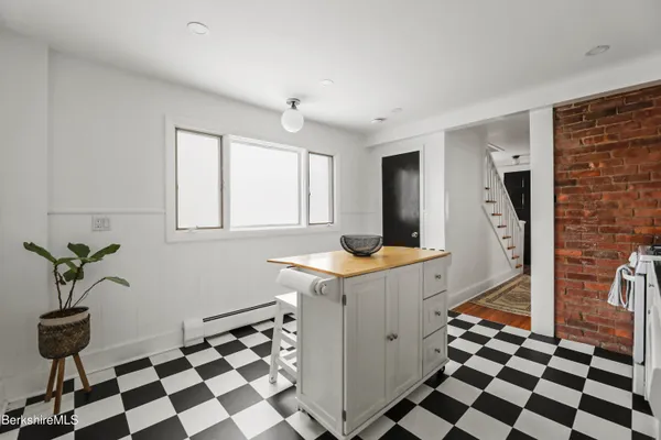 a kitchen with a checkered floor and white cabinets