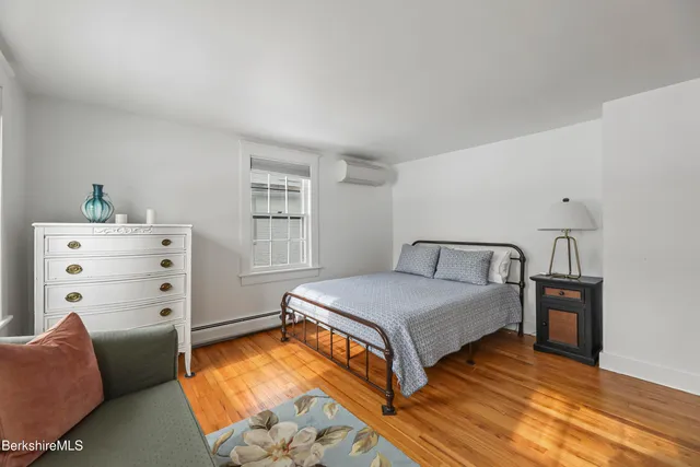 a bedroom with furniture and wooden floor