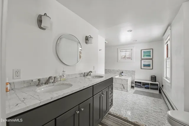 a en suite bathroom with a granite countertop sink a mirror and a