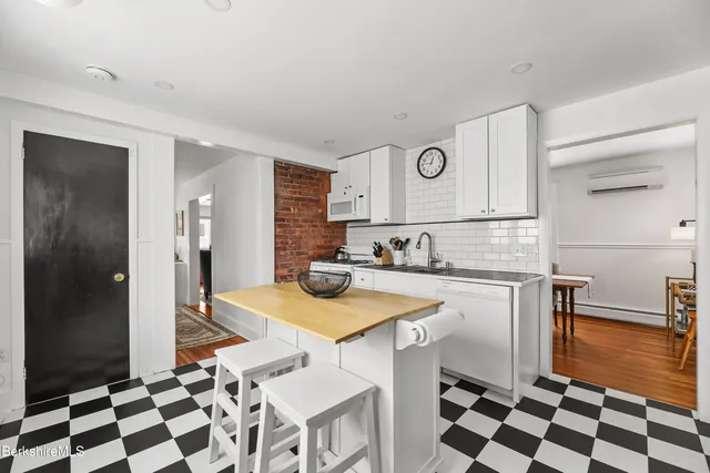 a kitchen with a sink a stove a refrigerator and white cabinets