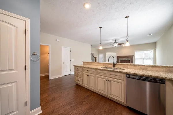 a kitchen with granite countertop a sink and a refrigerator