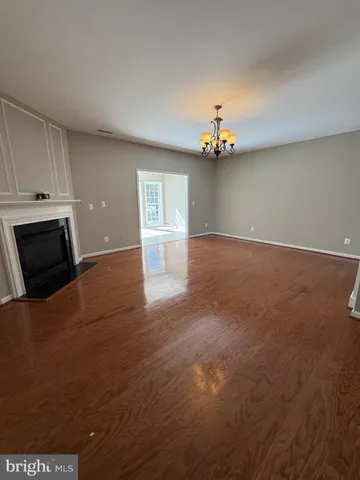 an empty room with windows and fireplace