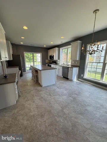 a large kitchen with a stove a sink dishwasher and a fireplace