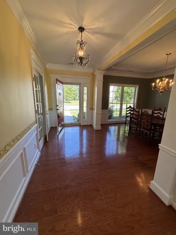 a view of a hallway with couches and chandelier