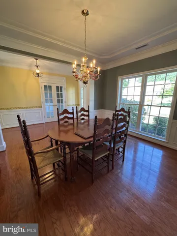 a view of a dining room with furniture wooden floor and chandelier