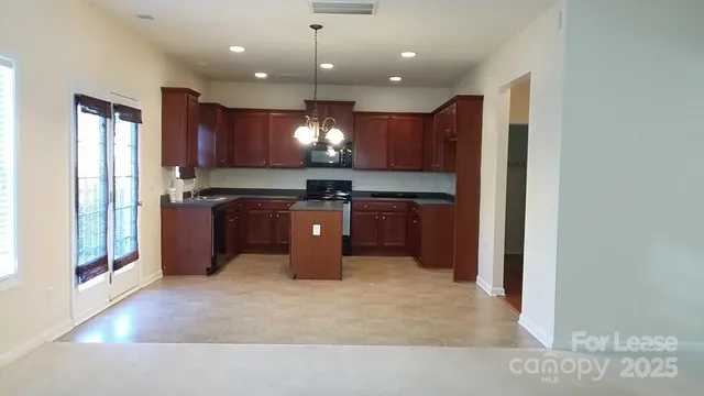 a kitchen with kitchen island a sink appliances and cabinets