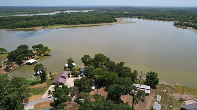 an aerial view of a house with outdoor space and lake view