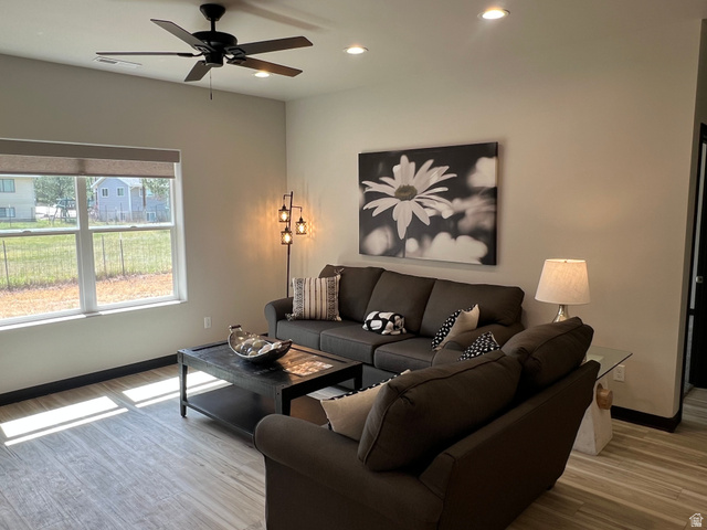 160 200 West Henefer, UT 84033 - Photo 9 of 25 Spacious living area featuring wood-finish flooring, a large window with roller shades, a ceiling fan, and recessed lighting