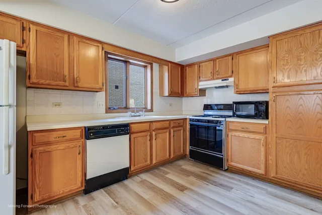 a kitchen with granite countertop wooden cabinets and white appliances