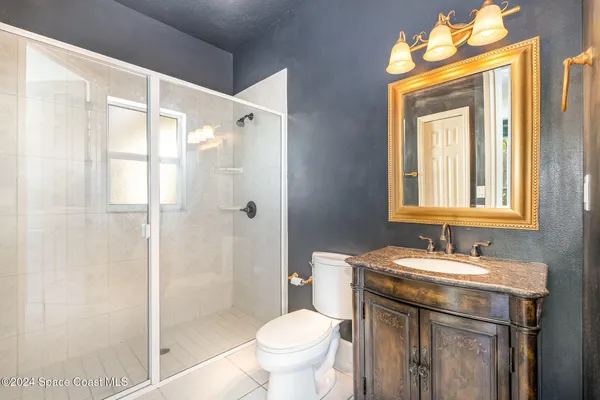 a bathroom with a granite countertop sink toilet and shower