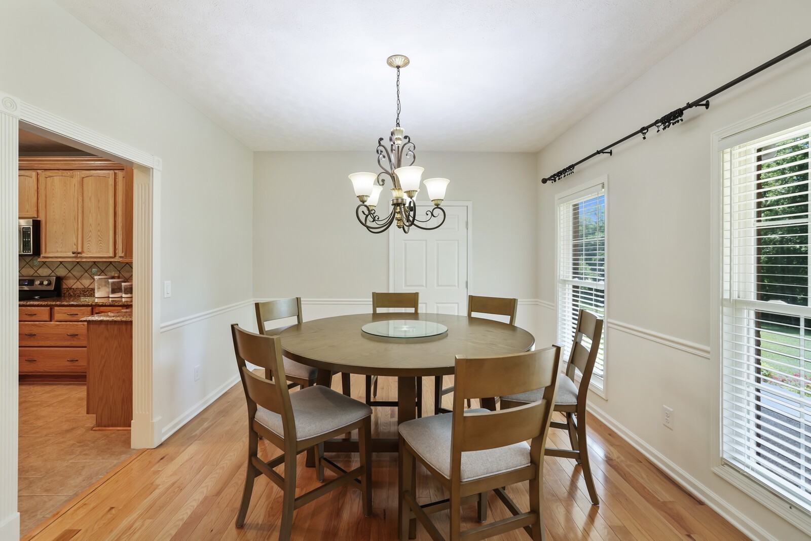 2219 Mack Benderman Road Culleoka, TN 38451 - Photo 6 of 40 a dining room with wooden floor a chandelier a wooden table and chairs