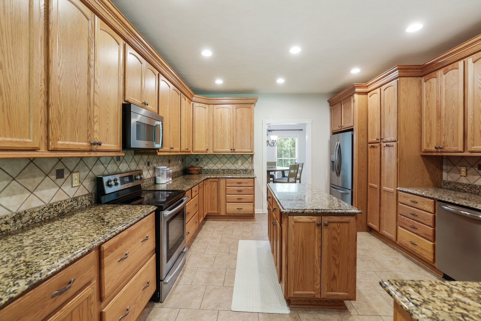 2219 Mack Benderman Road Culleoka, TN 38451 - Photo 7 of 40 a large kitchen with stainless steel appliances granite countertop a stove a sink and a refrigerator