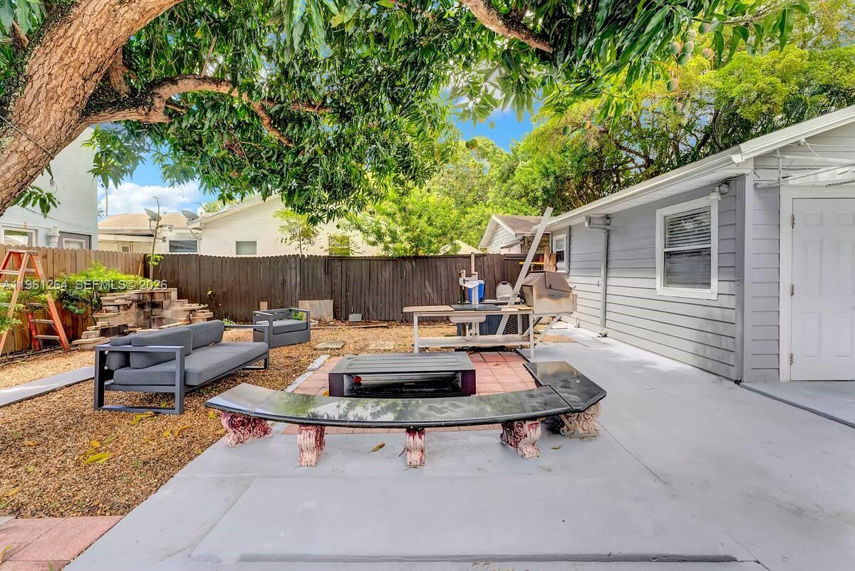 107 Stirling Road Dania Beach, FL 33004 - Photo 3 of 17 a backyard of a house with table and chairs