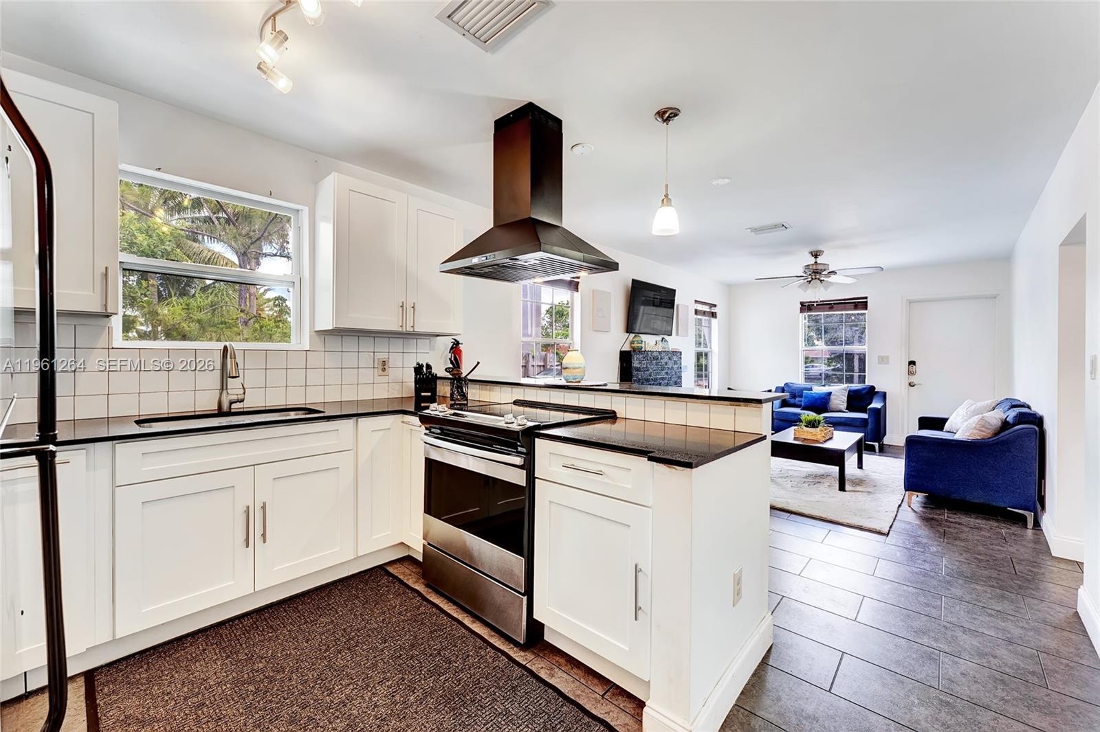 107 Stirling Road Dania Beach, FL 33004 - Photo 6 of 17 a kitchen with stainless steel appliances granite countertop a stove and a sink