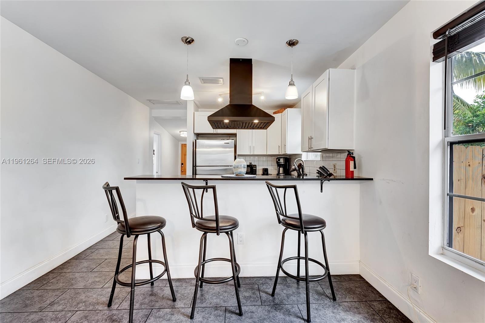 107 Stirling Road Dania Beach, FL 33004 - Photo 8 of 17 a kitchen with stainless steel appliances a microwave and a table