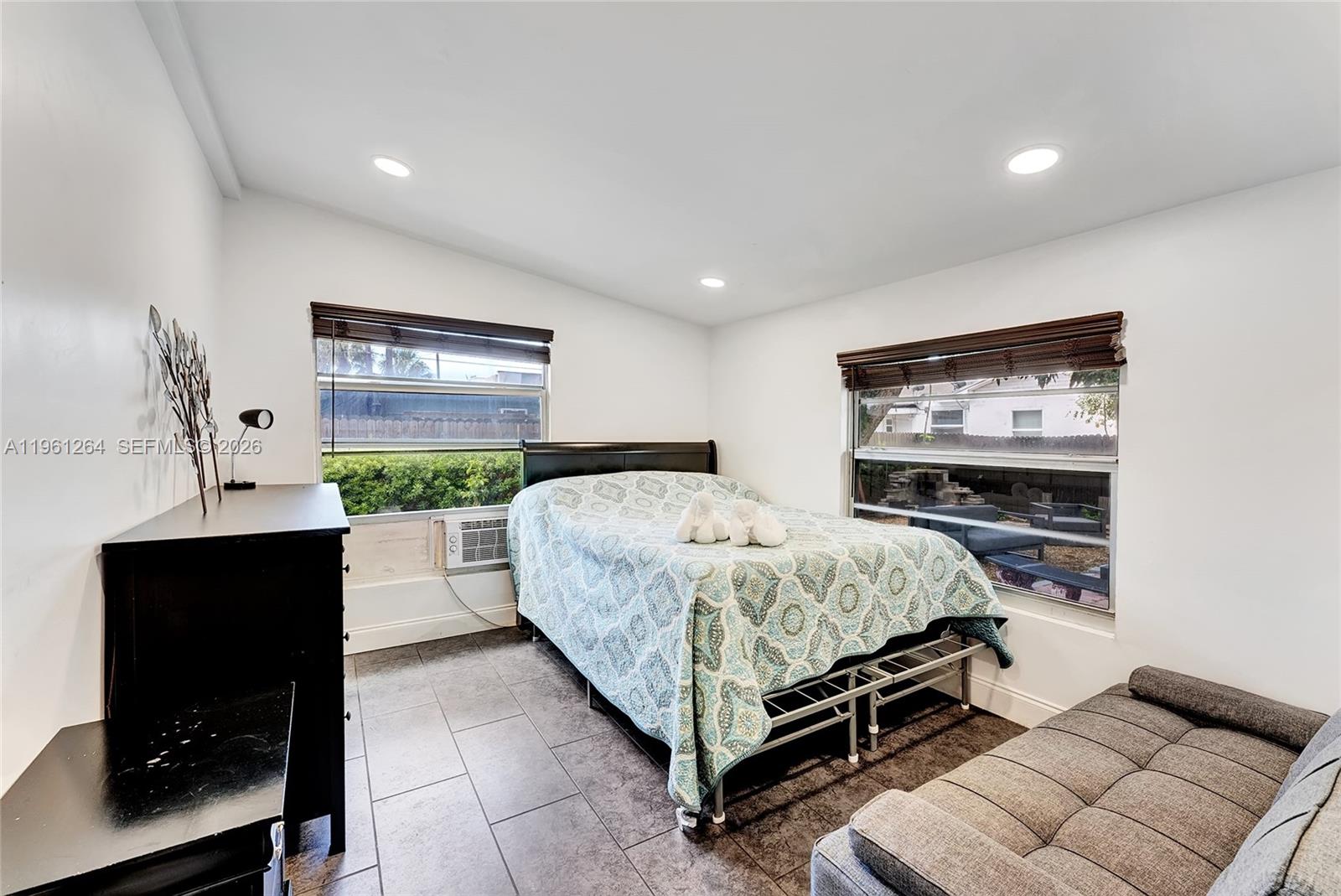 107 Stirling Road Dania Beach, FL 33004 - Photo 9 of 17 a spacious bedroom with a bed and a flat screen tv