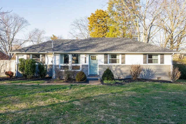 a view of a house with a yard and sitting area