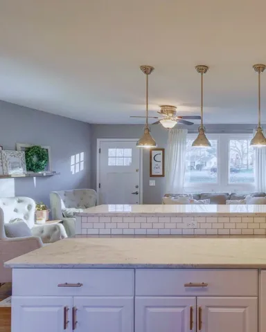 a kitchen with kitchen island sink and living room view