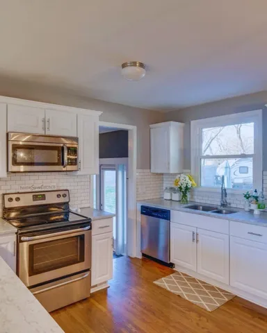 a kitchen with granite countertop a stove cabinets and microwave