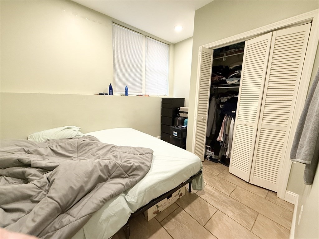 299 Dudley Street, Unit 2 Boston, MA 02119 - Photo 5 of 6 a bedroom with a bed and a flat screen tv