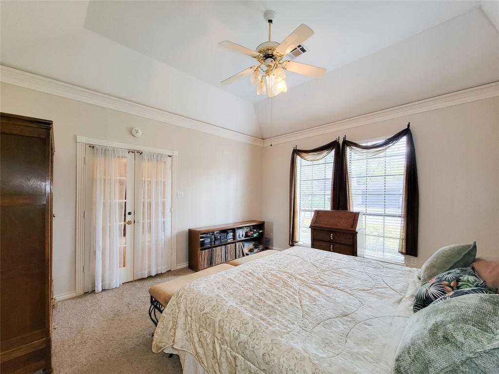 5810 Glenmere Lane Spring, TX 77379 - Photo 23 of 46 a bedroom with a large bed and a chandelier