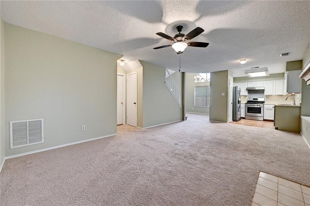 An open layout connects the carpeted living space directly to the kitchen area.