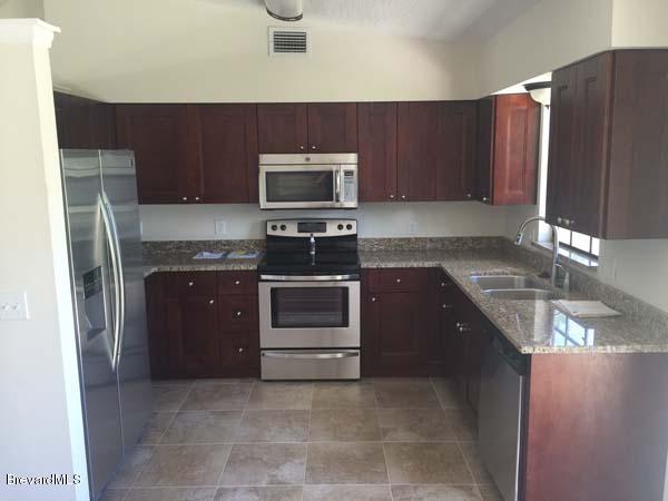 630 Weaver Road Southwest Palm Bay, FL 32908 - Photo 3 of 11 a kitchen with a sink and a stove top oven