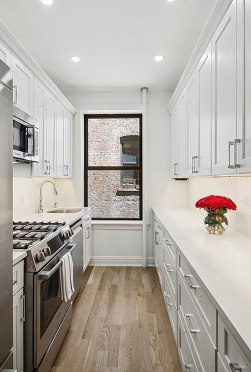 575 Riverside Drive, Unit 42 Manhattan, NY 10031 - Photo 10 of 12 a kitchen with a sink stove top oven and cabinets