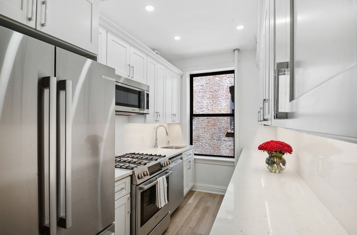 575 Riverside Drive, Unit 42 Manhattan, NY 10031 - Photo 9 of 12 a kitchen with stainless steel appliances kitchen island granite countertop a refrigerator and a stove