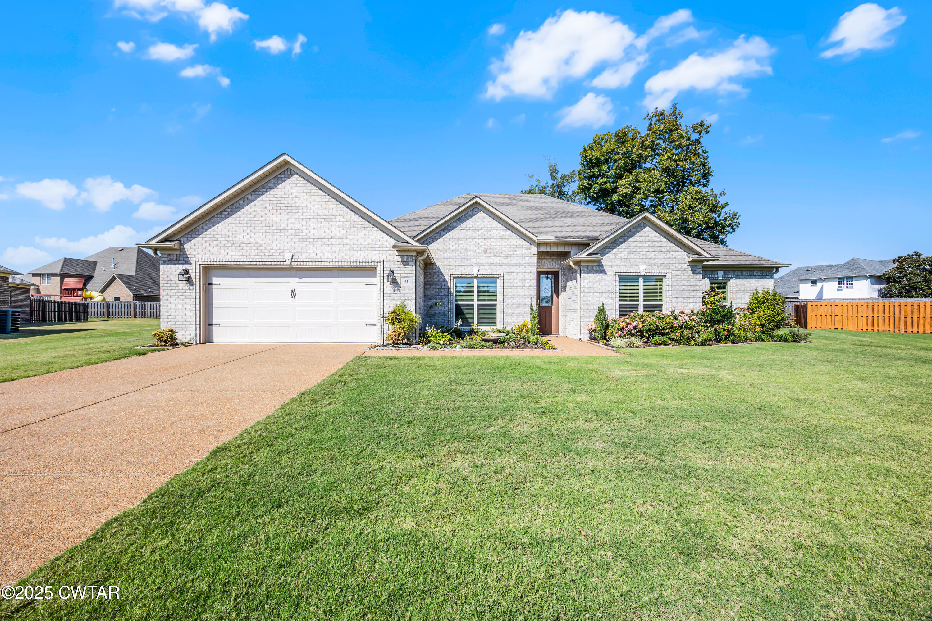 a front view of a house with a garden and yard