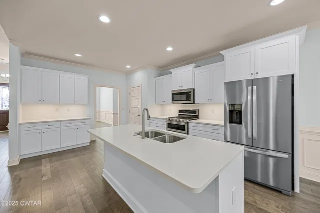 a kitchen with white cabinets and stainless steel appliances