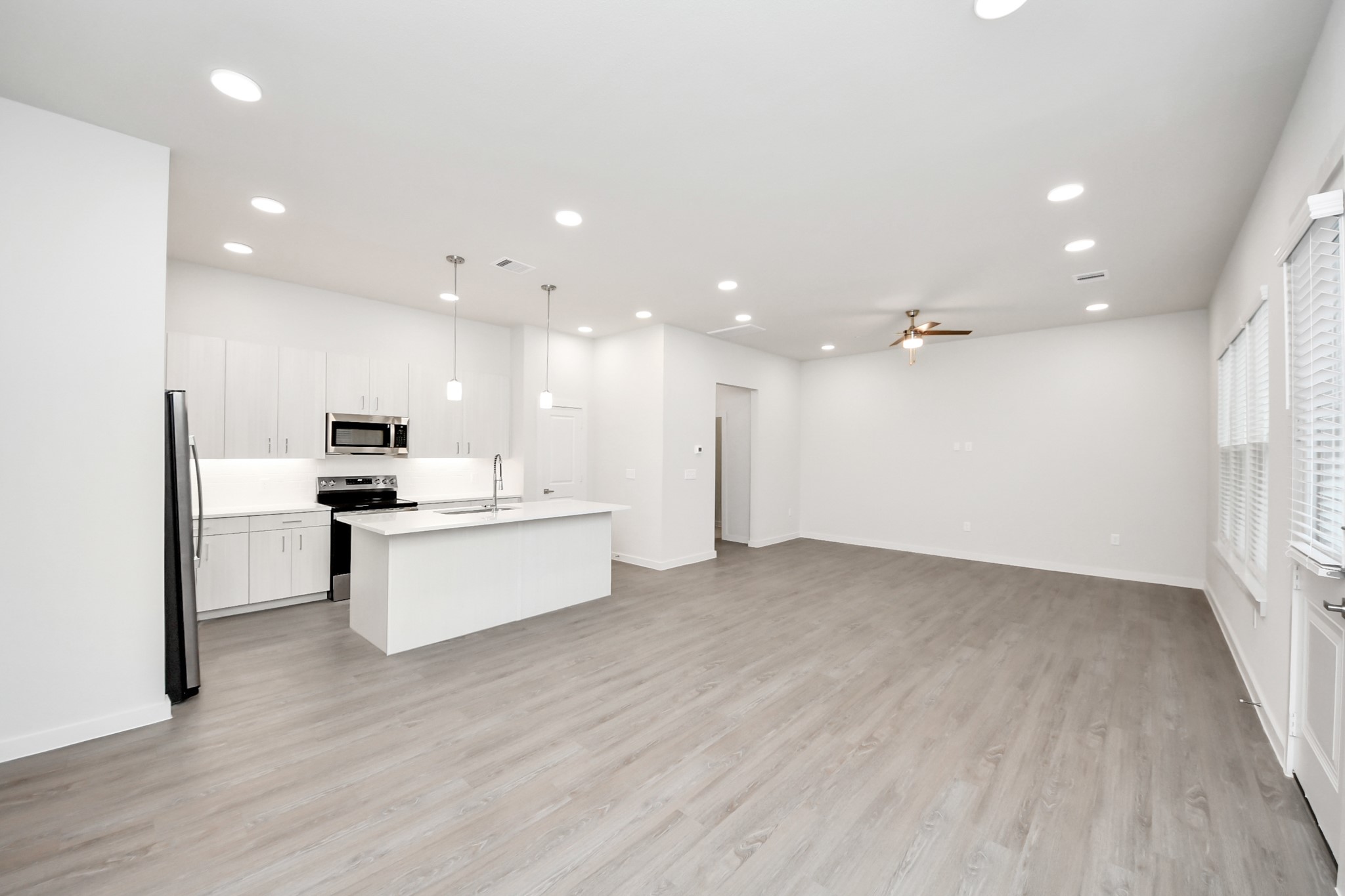 7306 Corey Rushing Lane Richmond, TX 77407 - Photo 10 of 49 Boasting modern finishes, quartz counters, tile backsplash,stainless appliances,refrigerator,washer & dryer,walk-in pantries,walk-in closets,wood-like floors throughout,9ft ceilings