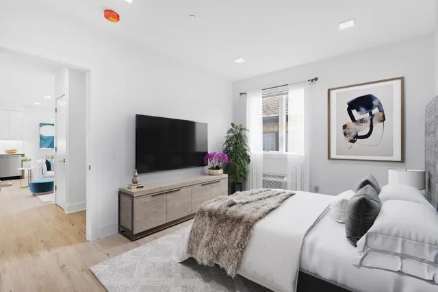 a bedroom with a bed and a flat screen tv