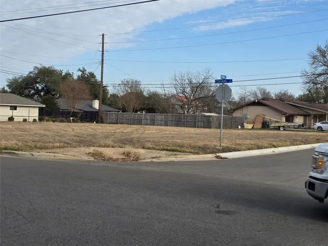 a view of a house with a yard and palm trees