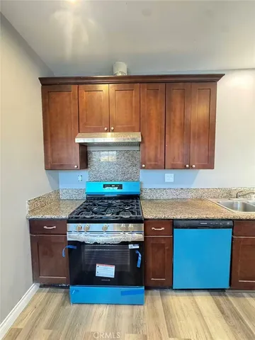 a kitchen with granite countertop a stove and a sink