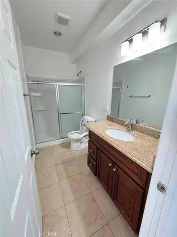 a bathroom with a granite countertop sink toilet and shower