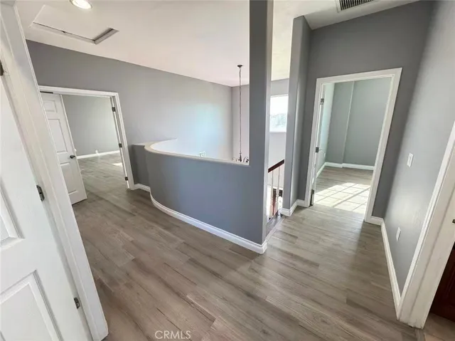 a view of entryway and hall with wooden floor