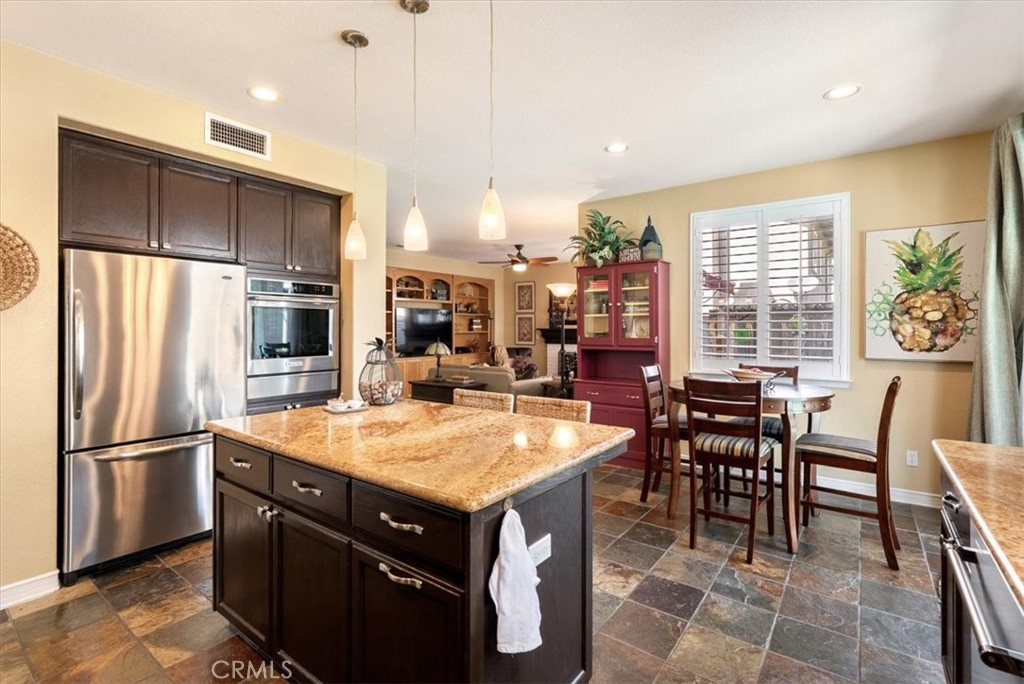 1945 Fieldstone Circle Paso Robles, CA 93446 - Photo 11 of 48 a kitchen with stainless steel appliances granite countertop a table chairs sink refrigerator and microwave