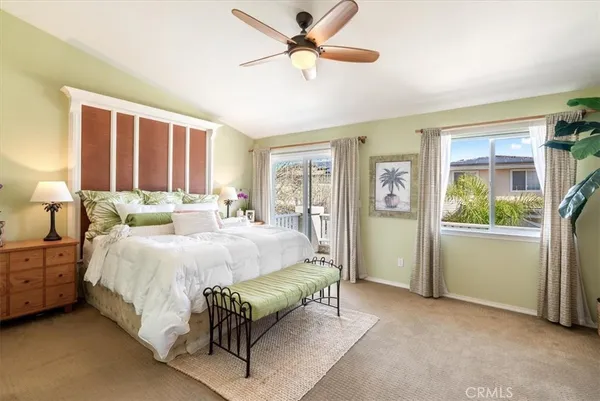a spacious bedroom with a bed and a chandelier fan