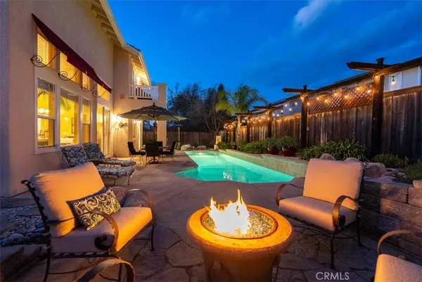 a backyard of a house with fountain table and chairs