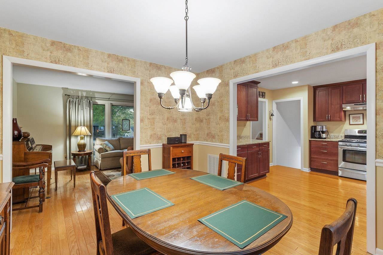 809 Silver Leaf Place Raleigh, NC 27609 - Photo 15 of 34 a living room with dining table a table chairs and couches with wooden floor