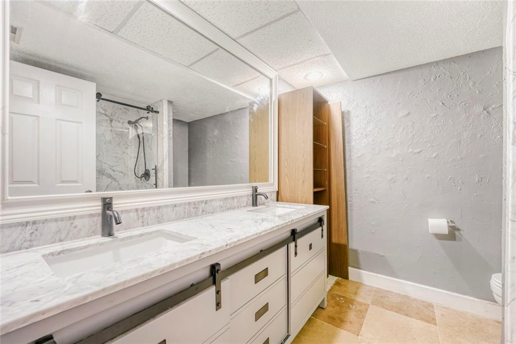 6851 Roswell Road, Unit M13 Atlanta, GA 30328 - Photo 21 of 28 a bathroom with a granite countertop sink and a mirror