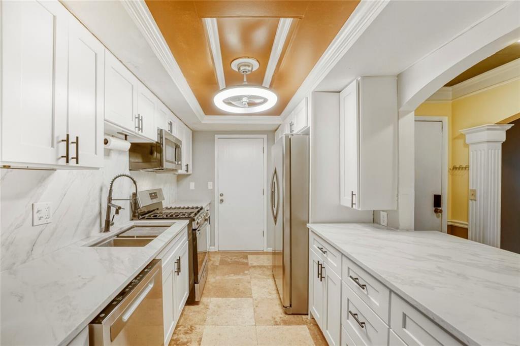 6851 Roswell Road, Unit M13 Atlanta, GA 30328 - Photo 10 of 28 a kitchen with stainless steel appliances granite countertop a sink and a stove