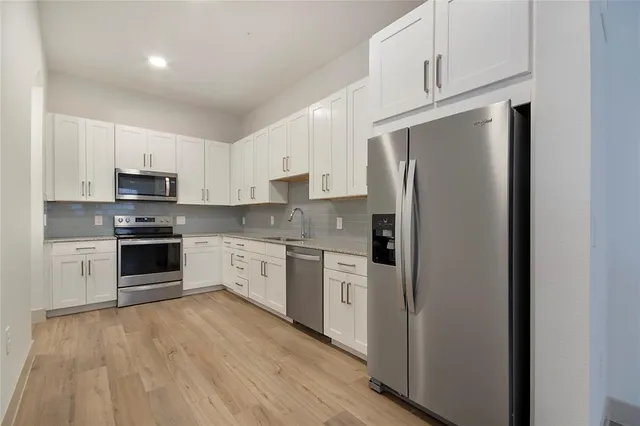 a kitchen with a refrigerator stove and white cabinets