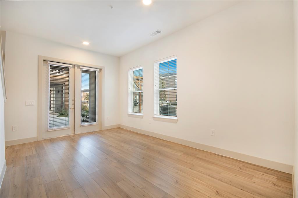 4700 West Spring Creek Parkway, Unit 9103 Plano, TX 75024 - Photo 5 of 40 an empty room with wooden floor and windows