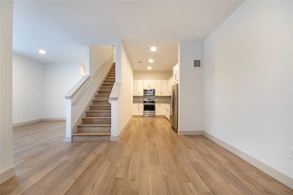 4700 West Spring Creek Parkway, Unit 9103 Plano, TX 75024 - Photo 6 of 40 a view of a hallway with wooden floor and staircase
